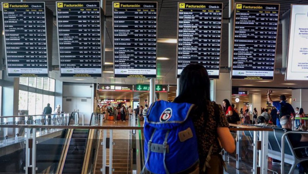 ep archivo   una mujer con una mochila observa los paneles de facturacion en el aeropuerto adolfo