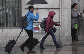ep dos turistas se refugian de la lluvia con paraguas imagen de archivo