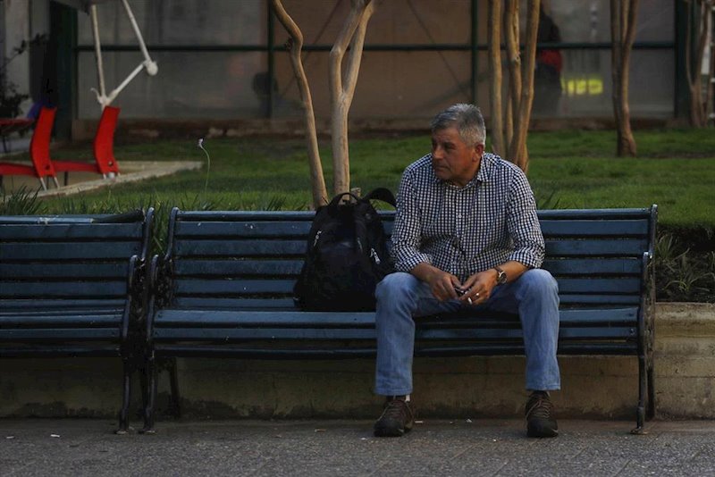 ep un hombre sentado en un banco en una calle de santiago