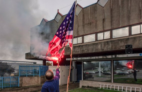 ep archivo - un trabajador de alcoa san cibrao quema una bandera de estados unidos delante de la