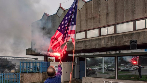 ep archivo - un trabajador de alcoa san cibrao quema una bandera de estados unidos delante de la
