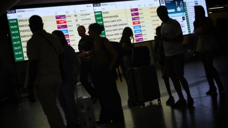 ep varias personas observan las pantallas informativas en la estacion de madrid   puerta de atocha  