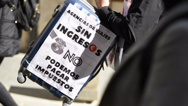 ep archivo   una mujer con una maleta y una pancarta participa en la concentracion de asociaciones