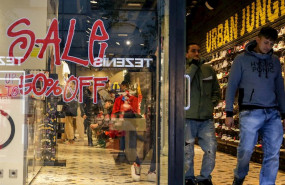 ep dos hombres salen de una tienda de zapatos en madrid donde se ofertan rebajas de hasta el 50