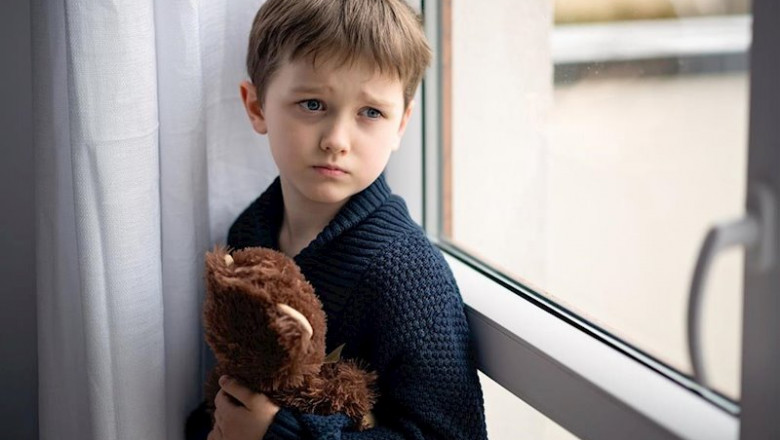 ep nino esta abrazando a su osito de peluche de pie junto a la ventana dia lluvioso concepto de ep nino esta abrazando a su osito de peluche de pie junto a la ventana dia lluvioso concepto de