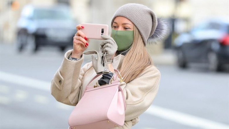 ep una mujer con mascarilla haciendo una foto con su smartphone en londres