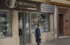 ep una mujer en la puerta de una tienda de articulos de peluqueria en sevilla andalucia espana a 30