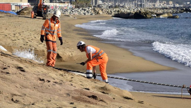 ep archivo   dos trabajadores con el cable submarino 2africa a su llegada a la barcelona cable
