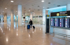 ep un pasajero pasa por delante de los paneles del aeropuerto el prat de barcelona