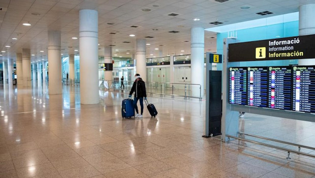 ep un pasajero pasa por delante de los paneles del aeropuerto el prat de barcelona