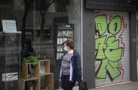 ep una mujer protegida con mascarilla y guantes camina con el carro de la compra delante de una