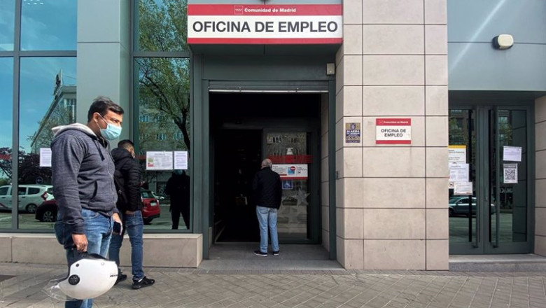 ep varias personas esperan en las inmediaciones de una oficina del sepe