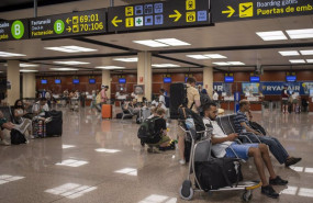 ep varias personas esperan sentadas con sus maletas en el aeropuerto josep tarradellas barcelona el