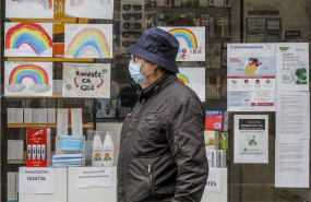 ep un hombre con mascarilla pasa junto a una farmacia con dibujos infantiles en su escaparate