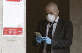 ep un hombre con mascarilla y guantes manipula un movil en las inmediaciones de un banco durante el
