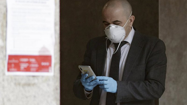 ep un hombre con mascarilla y guantes manipula un movil en las inmediaciones de un banco durante el