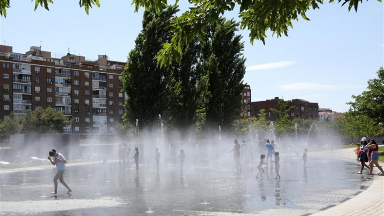 Varias personas, entre ellas niños, se refrescan en los chorros de Madrid Río un día antes de que, según la Agencia Estatal de Meteorología (AEMET), llegue a la península Ibérica y a las Islas Baleares la primera ola de calor del verano 2019. | Jesús Hellín - Europa Press ep varias personas entreninos se refrescanlos chorrosmadrid riodiade que segunagencia estatalmeteorologia aemet lleguela peninsula ibericaaislas balearesprimera olacalorverano 2019