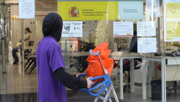 ep archivo   un joven pasa con una carretilla por una oficina de empleo de madrid