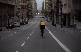 ep archivo   un trabajador de glovo en bicicleta por una calle de barcelona practicamente vacia