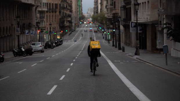 ep archivo   un trabajador de glovo en bicicleta por una calle de barcelona practicamente vacia