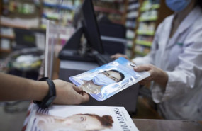 ep archivo   una farmaceutica ensena a un cliente un paquete de mascarillas en la farmacia situada