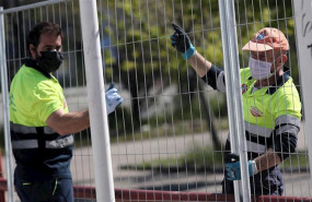 ep dos operarios protegidos con mascarilla verjan las zona exteriores pertenecientes al palacio de