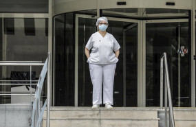 ep sanitaria protegida con mascarilla y gorro durante el minuto de silencio en la entrada del