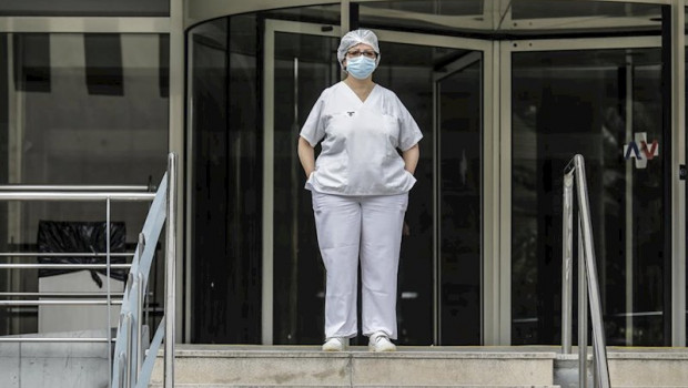 ep sanitaria protegida con mascarilla y gorro durante el minuto de silencio en la entrada del