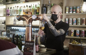 ep un camarero sirve una cerveza en el interior de un bar