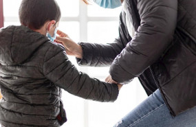 ep una madre coloca a su hijo una mascarilla