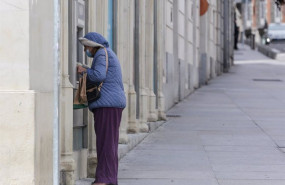 ep archivo   una mujer protegida con mascarilla y abrigada saca dinero de un cajero de madrid a 15