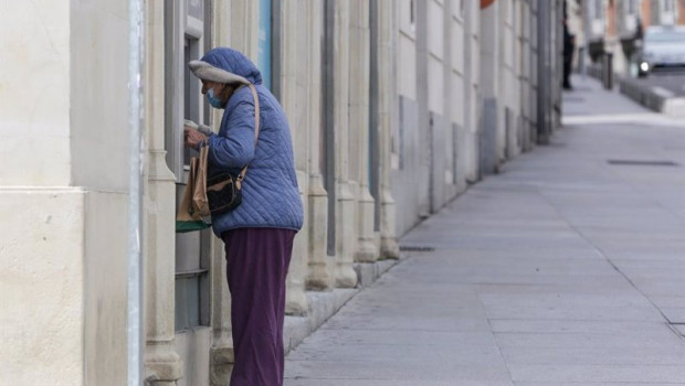 ep archivo   una mujer protegida con mascarilla y abrigada saca dinero de un cajero de madrid a 15