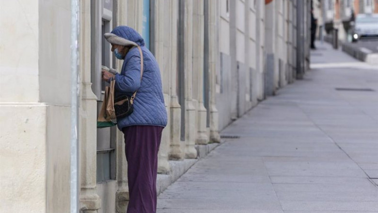 Archivo - Una mujer protegida con mascarilla y abrigada saca dinero de un cajero de Madrid, a 15 de abril de 2020. | Ricardo Rubio - Europa Press - Archivo ep archivo una mujer protegida con mascarilla y abrigada saca dinero de un cajero de madrid a 15