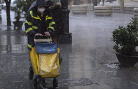 ep archivo   un repartidor de correos trabaja bajo la lluvia protegido con un impermeable