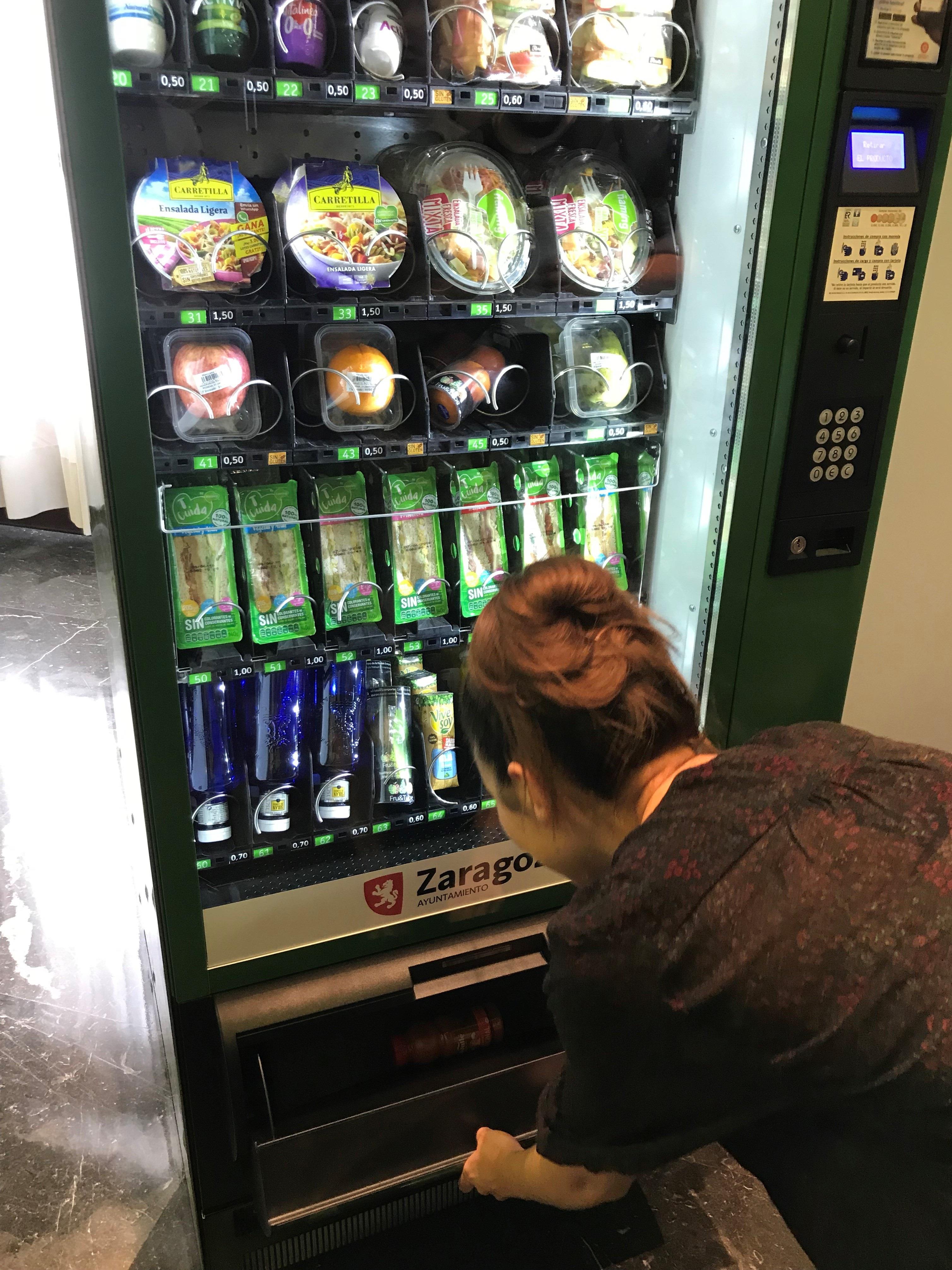 ep una joven adquiereproducto saludableuna maquina expendedora
