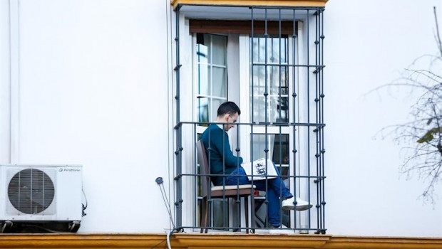ep un ciudadano aprovecha su minusculo balcon para leer en la tercera semana de confinamiento por el