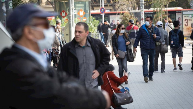 ep dos personas caminan en zonas cercanas a la sagrada familia protegidos con mascarillas ante el