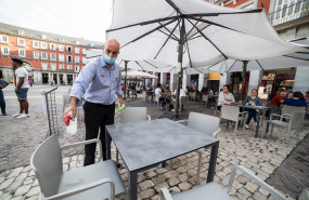ep un camarero desinfecta una mesa
