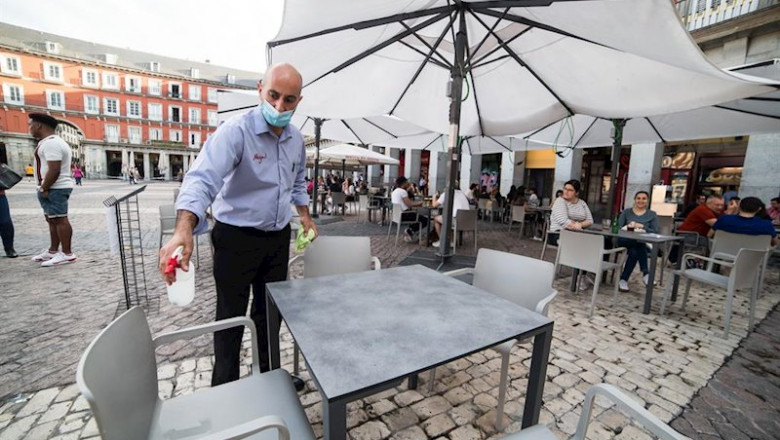 ep un camarero desinfecta una mesa