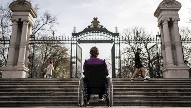 ep cristina en silla de ruedas ante una escalinata en la puerta de espana del parque del retiro en
