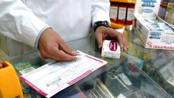 Un farmacéutico consulta la receta de un paciente en una farmacia | AMNISTÍA INTERNACIONAL - Archivo ep un farmaceutico consulta la receta de un paciente en una farmacia
