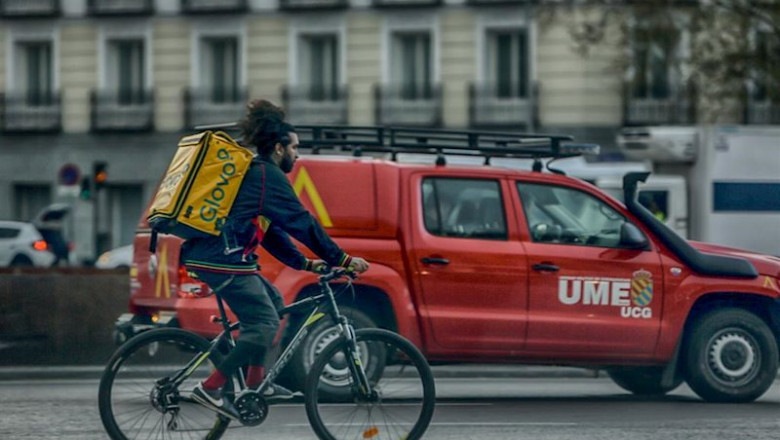 Un repartidor en bici circula por una calle de Madrid al lado de un vehículo de la UME el 15 de marzo de 2020. | Ricardo Rubio - Europa Press ep un repartidor en bici circula por una calle de madrid al lado de un vehiculo de la ume el 15 de