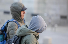 ep dos jovenes se protegen del frio con abrigos y gorros mientras pasean durante un dia de viento