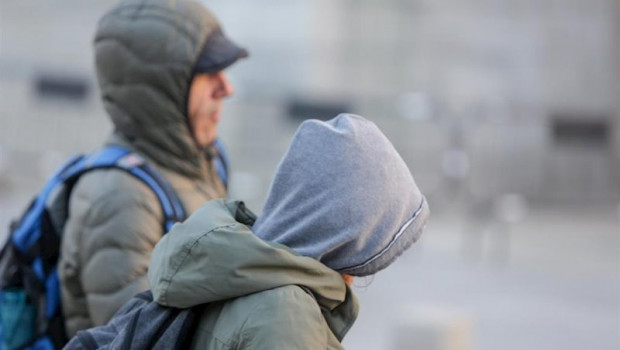 ep dos jovenes se protegen del frio con abrigos y gorros mientras pasean durante un dia de viento