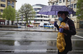 ep una mujer se protege de la lluvia con un paraguas mientras camina con una bolsa de patatas