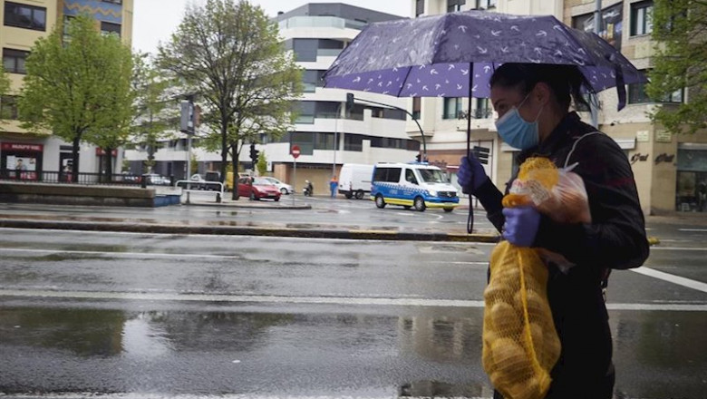ep una mujer se protege de la lluvia con un paraguas mientras camina con una bolsa de patatas ep una mujer se protege de la lluvia con un paraguas mientras camina con una bolsa de patatas