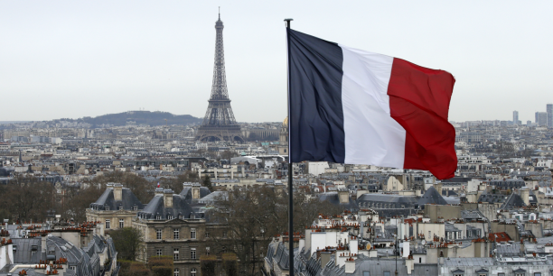 un drapeau francais flotte au dessus de l horizon alors que la tour eiffel et les toits sont vus a paris france 20240425135820 