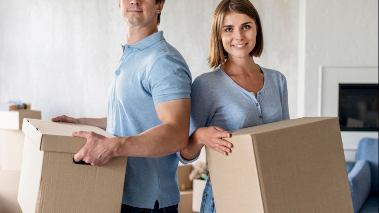 1238409 smiley couple holding boxes moving out day