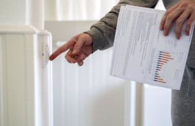 ep archivo   un hombre enciende un interruptor con una factura de luz en la mano