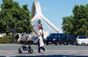 ep una madre pasea a su hijo con el puente de la barqueta detras un dia despues de que el gobierno